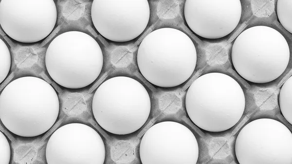 Frango inteiro assado de pele dourada e crocante numa assadeira cercado de batatas coradas no próprio caldo