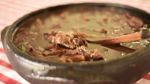 Concha tirando feijão carioca de caldo grosso e encorpado de uma panela