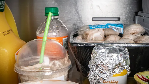 Geladeira aberta com potes de comida guardados em prateleiras organizadas