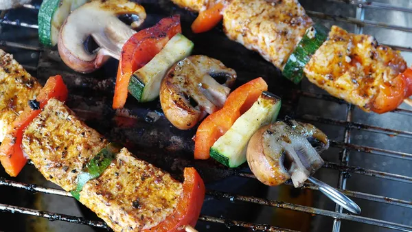 Costelinha suína na brasa pincelada com barbecue caseiro brilhante, com a carne soltando do osso e a casca caramelizada