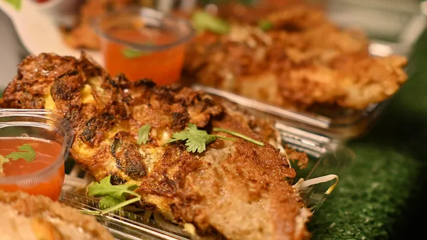 Espetinhos de frango dourados na grelha da churrasqueira, com cubos uniformes levemente caramelizados e marcas de grelha