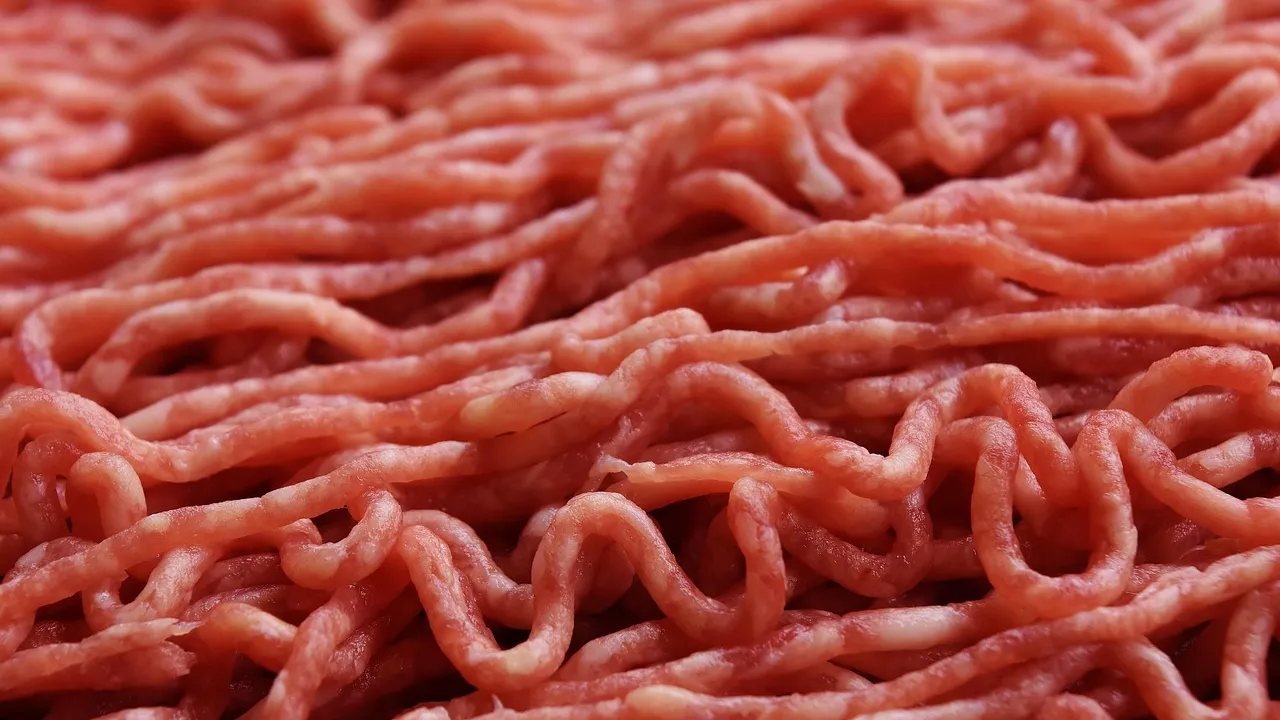 Gomos de linguiça artesanal dourados na grelha da churrasqueira ao lado de uma frigideira de ferro com farofa amarela