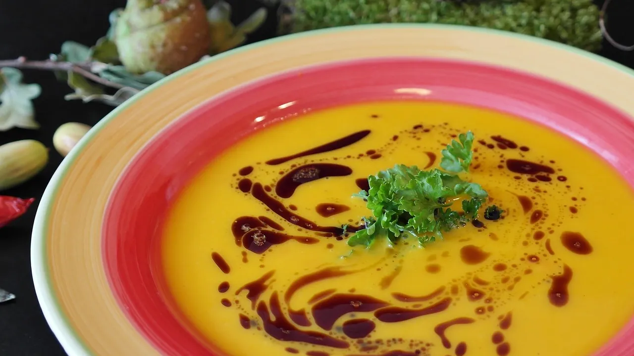 Prato fundo com risoto de abóbora cremoso alaranjado, lascas de parmesão e sálvia por cima